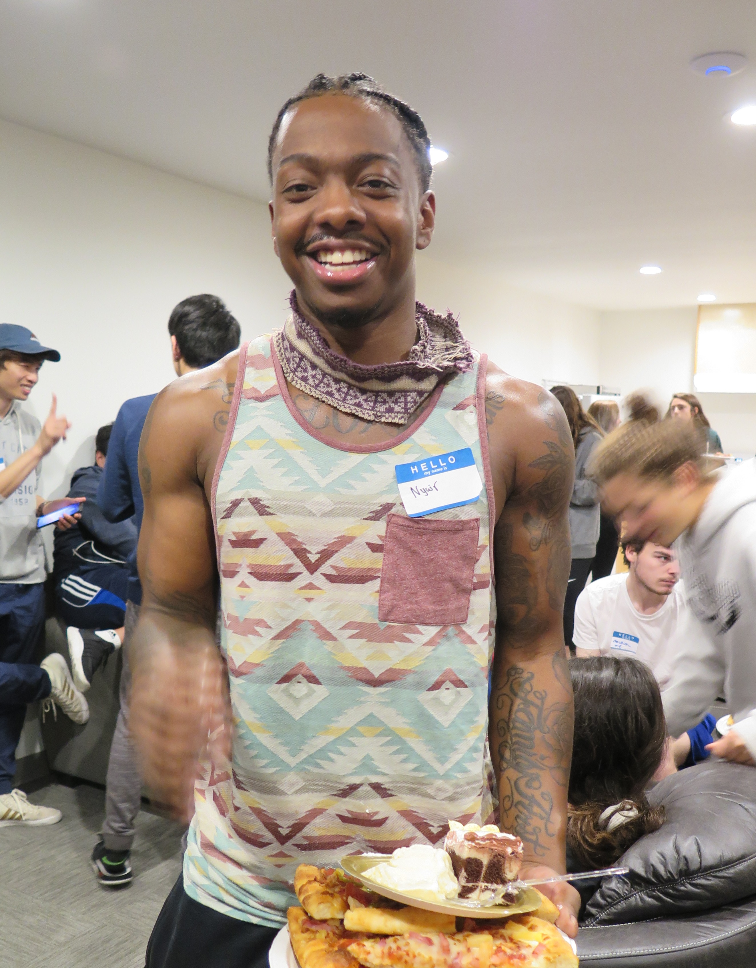 Smiling man holding pizza, cake, and ice cream