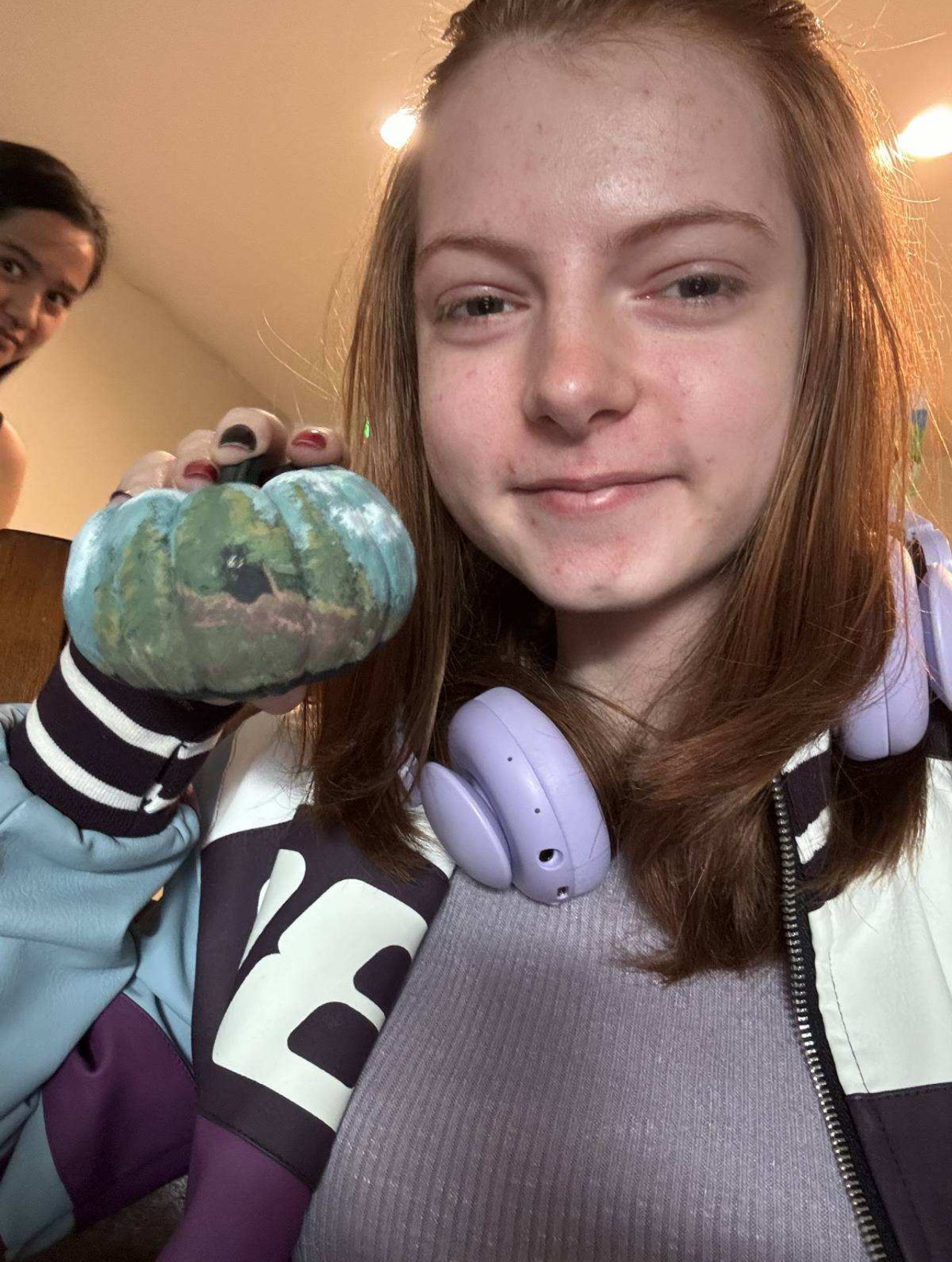 Resident with her pumpkin that is painted with a forest scene