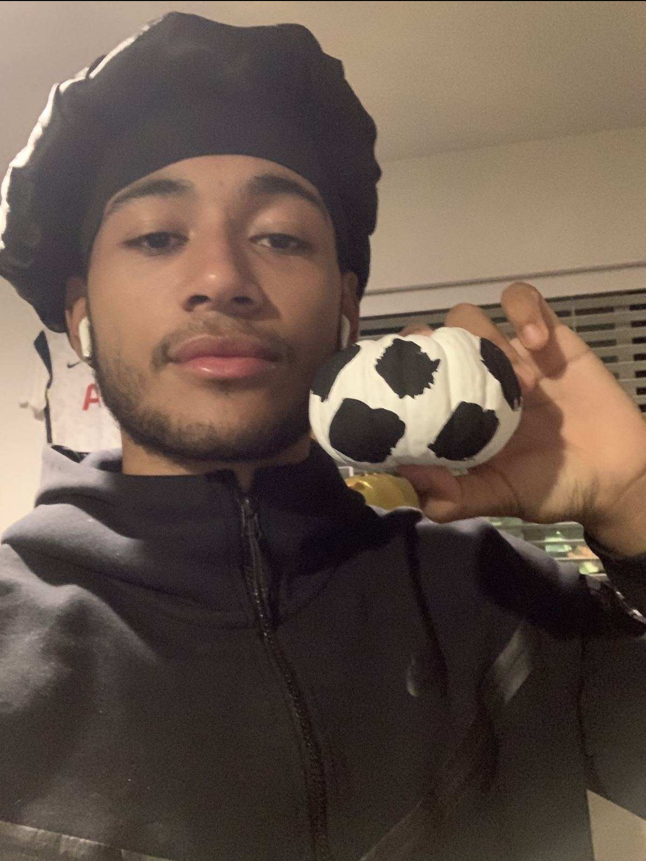 Resident holding his pumpkin, whihch is painted like a soccer ball.